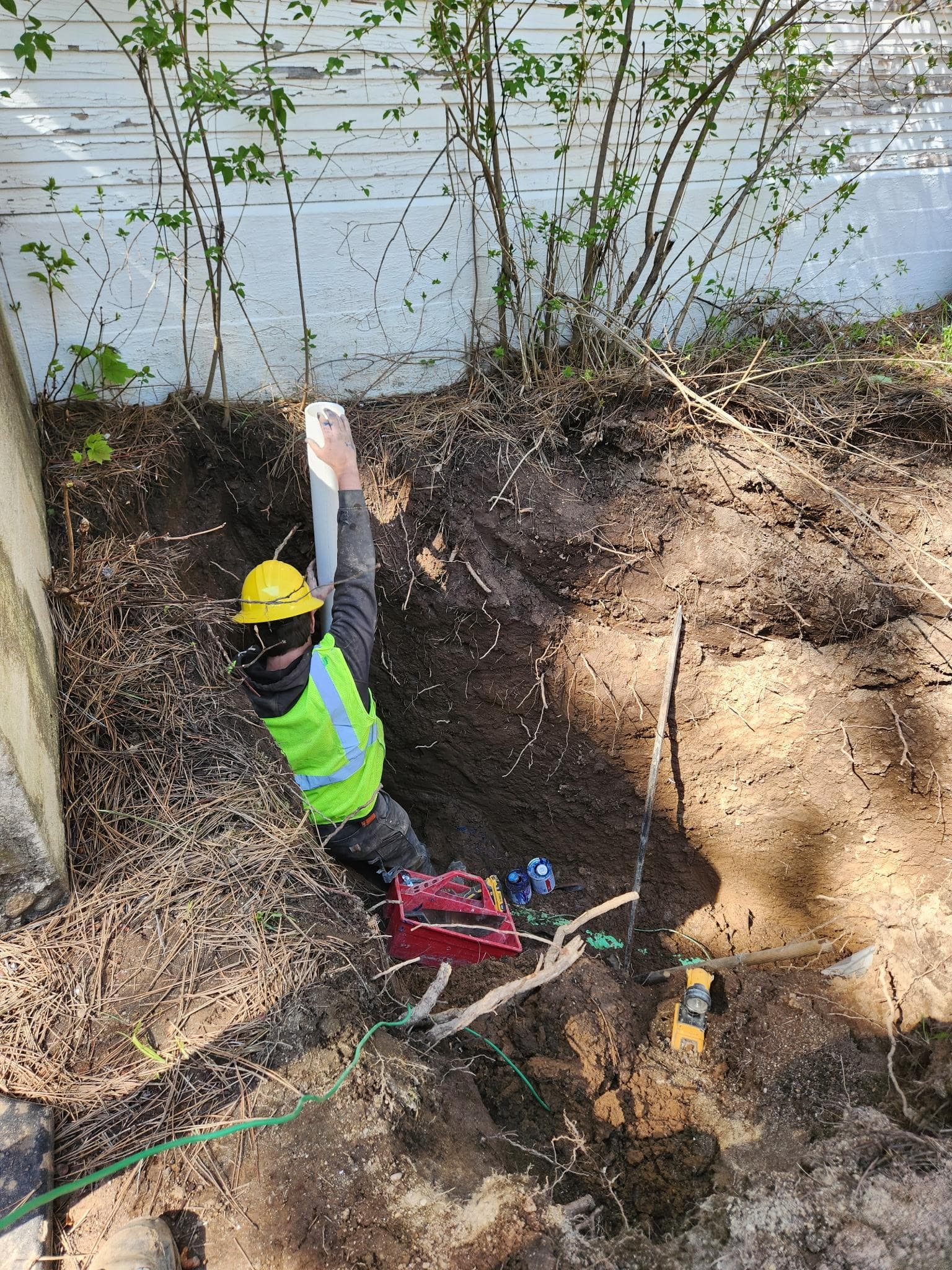 Goff's Plumbing crew member working through an active drainfield trench.